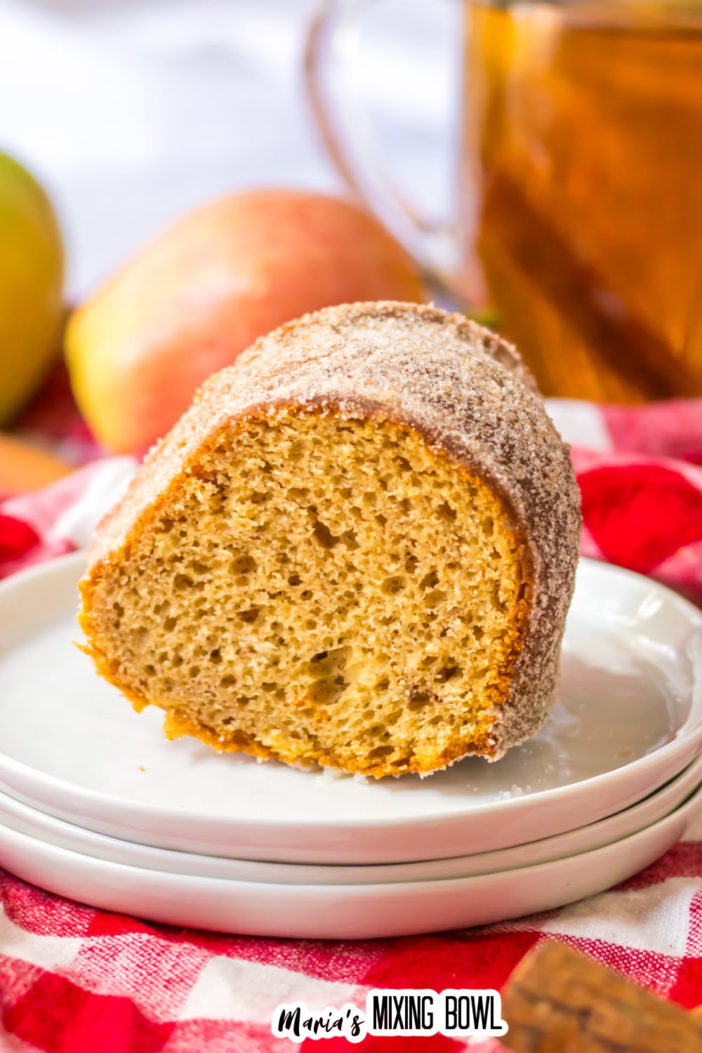 slice of apple cider donut cake stacked on top of three small plates.