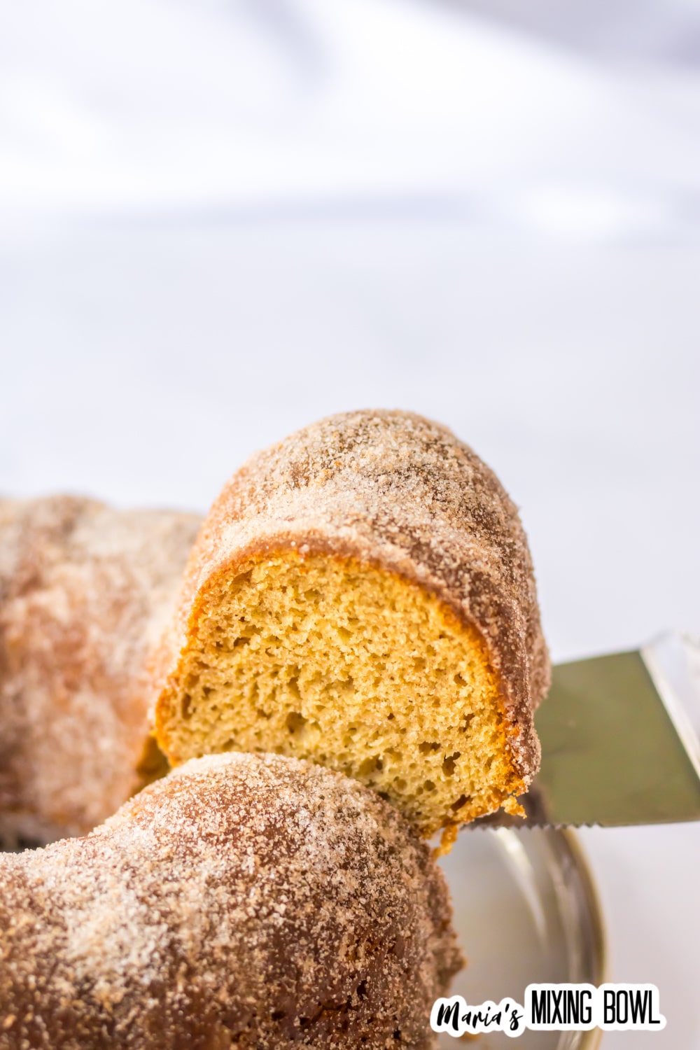 slice of apple cider donut cake being removed with a cake cutter.
