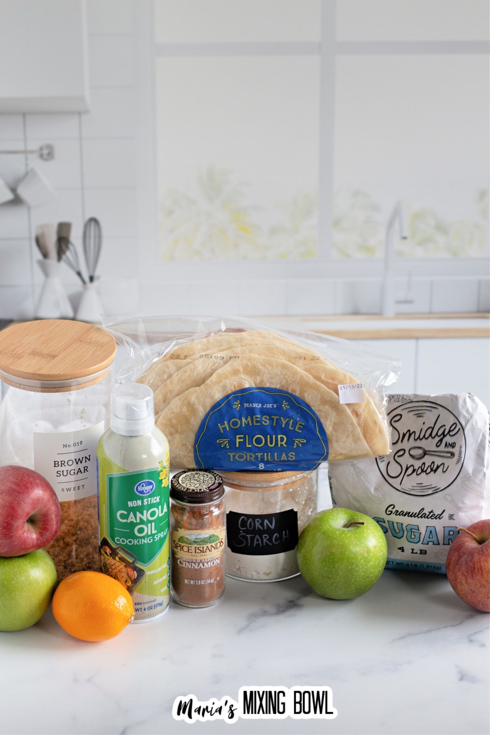 packages of brown sugar, cooking spray, tortillas, cinnamon, cornstarch, granulated sugar, and apples on a counter.