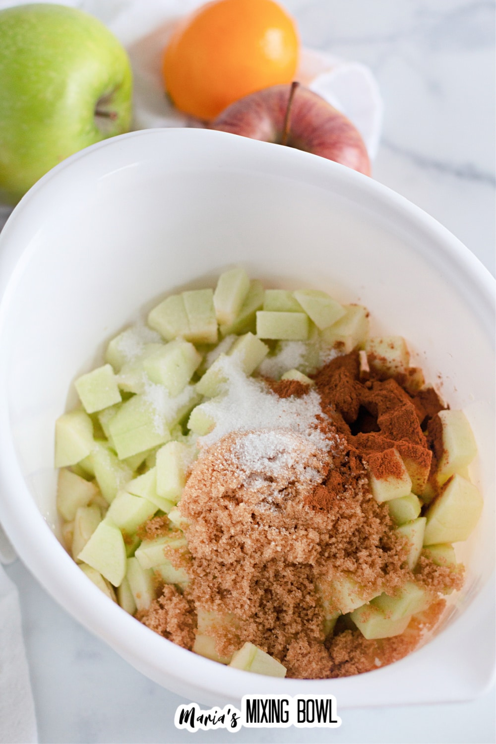 mixing bowl fille with diced apples, cinnamon, and brown sugar.