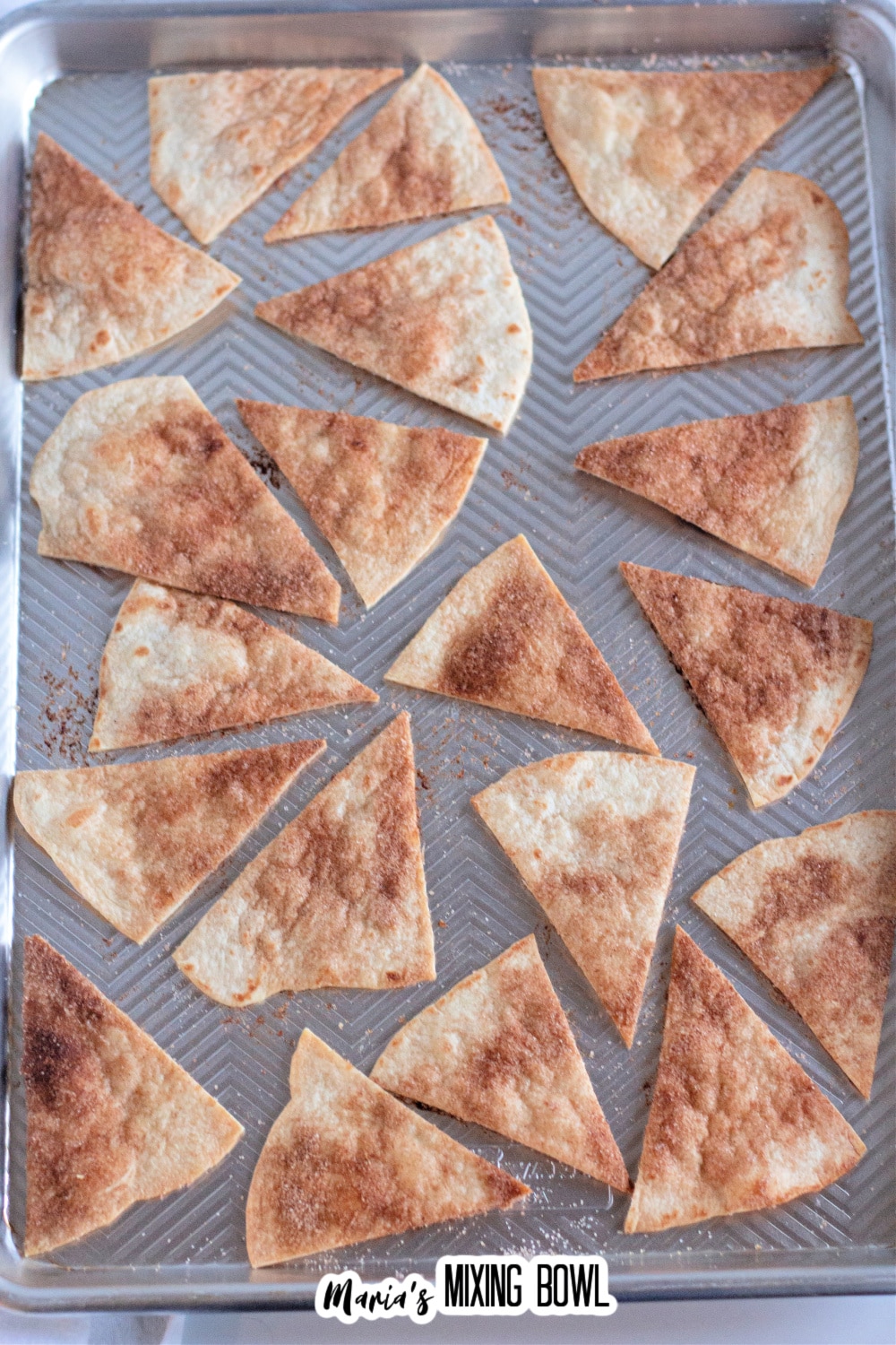 baked cinnamon sugar tortilla chips on a baking sheet.