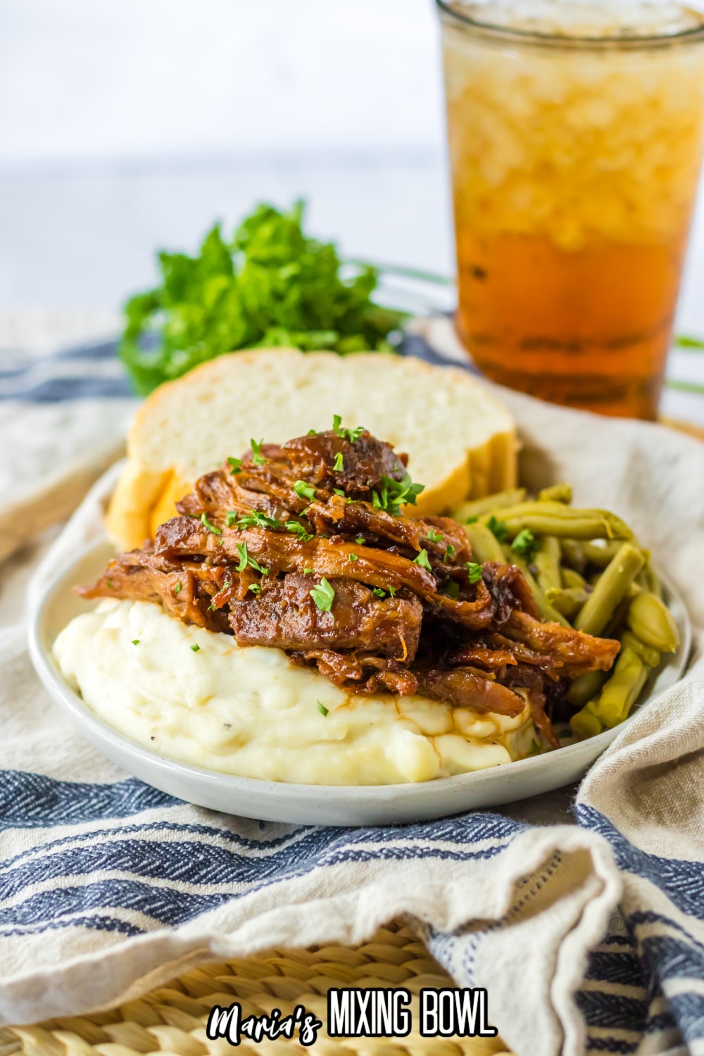 shredded pork loin on top of a bed of mashed potatoes on a plate.
