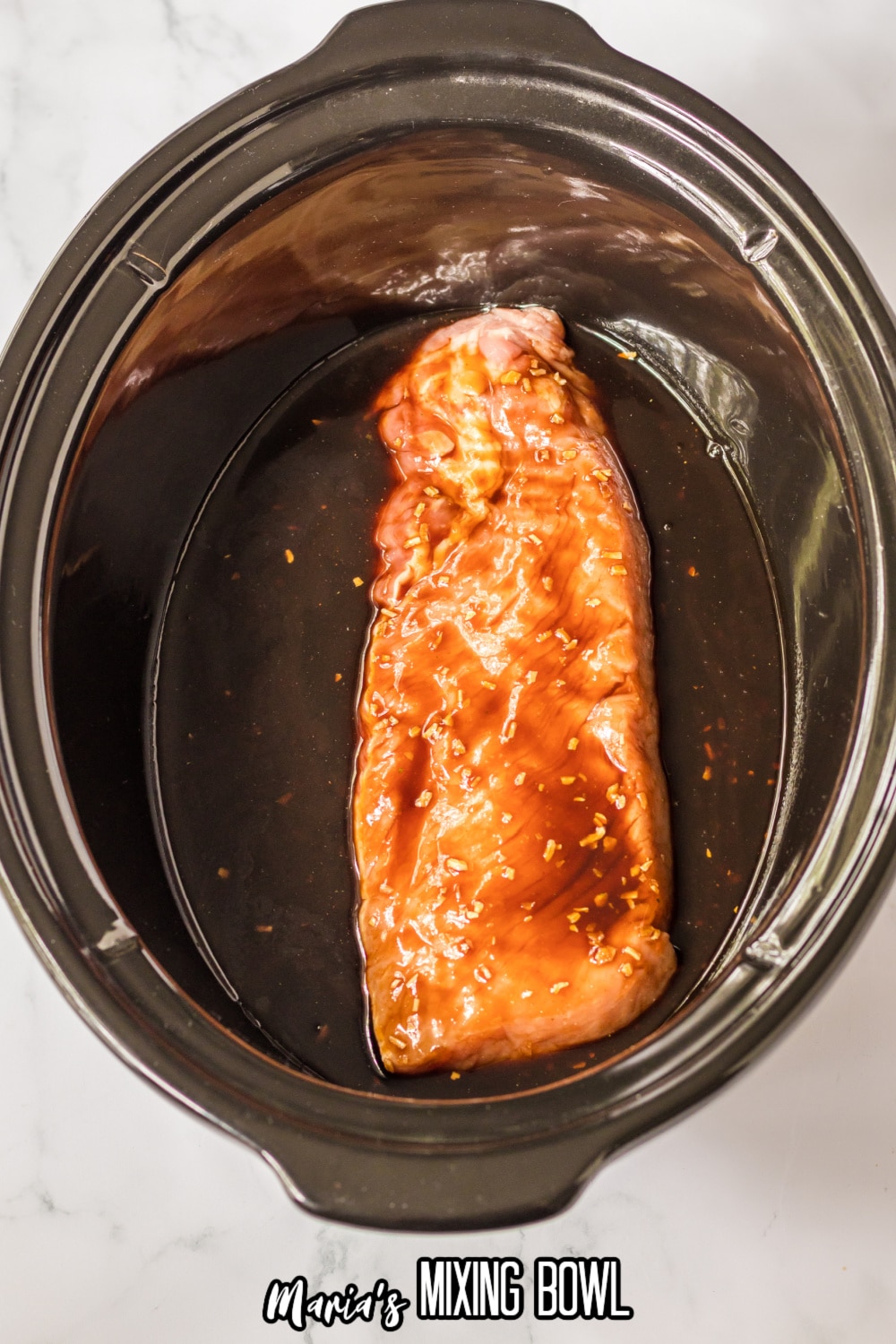 raw pork loin, topped with balsamic pork loin in a slow cooker.