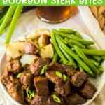 white plate filled with bourbon steak bites, cooked potatoes, and green beans.