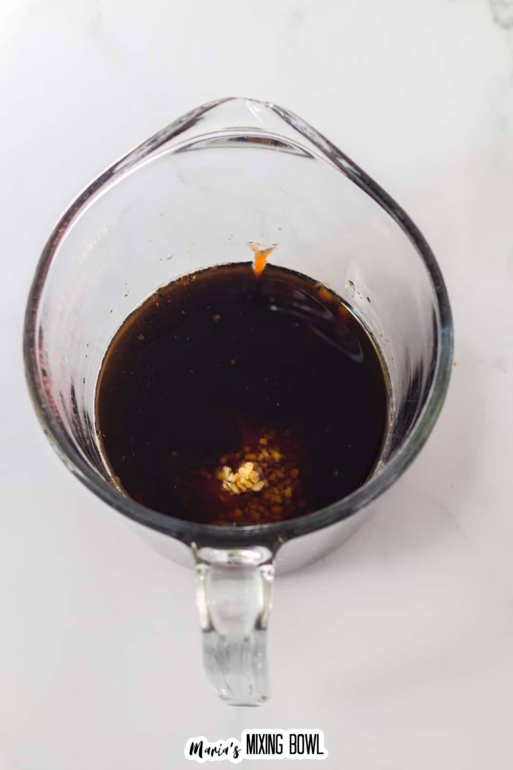 honey bourbon sauce in a glass measuring cup ready to pour into the slow cooker.