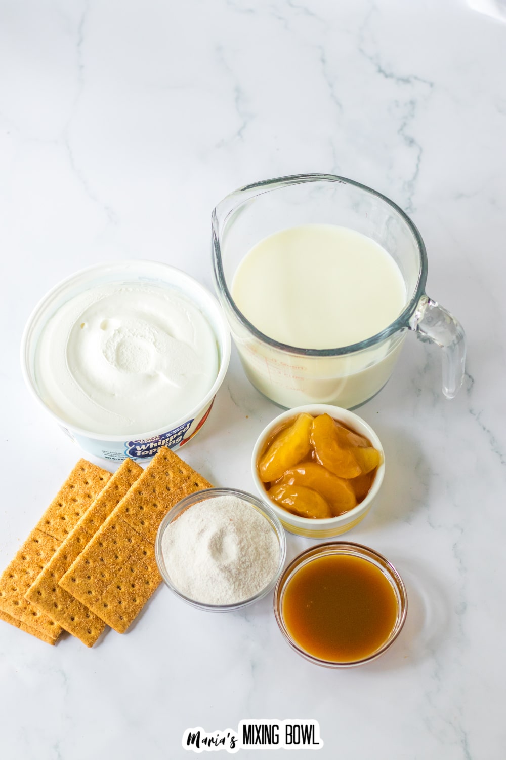 bowls of whipped topping, milk, pudding mix, apple pie filling, caramel sauce, and graham crackers.