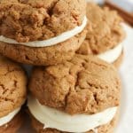 carrot cake mix sandwich cookies stacked on a white plate.