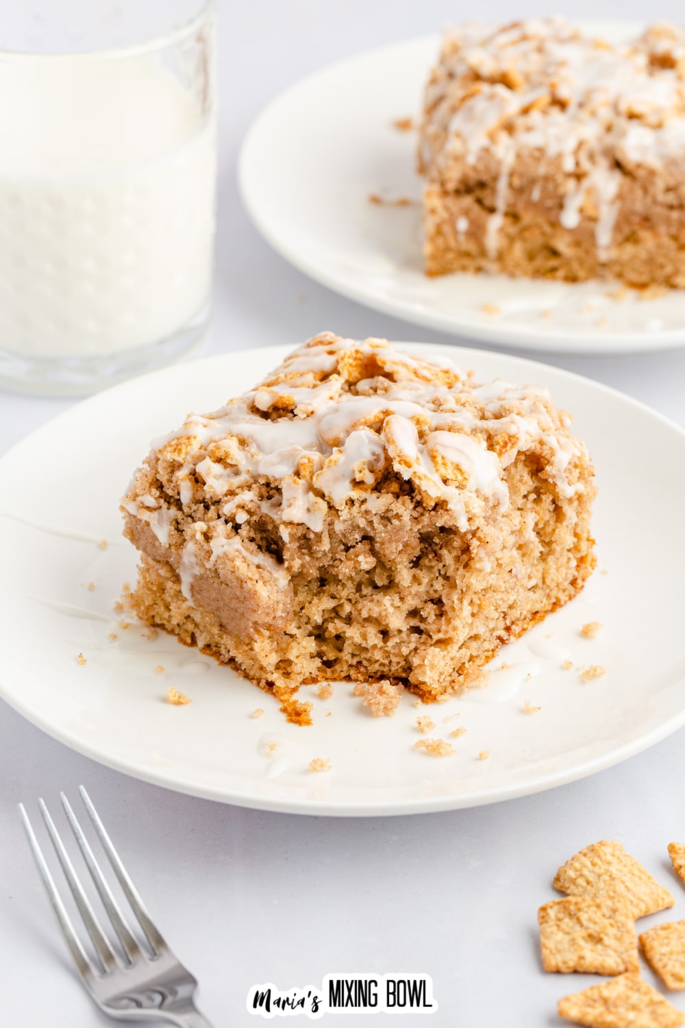 slice of cinnamon toast crunch cake on a small white plate with a bite missing.