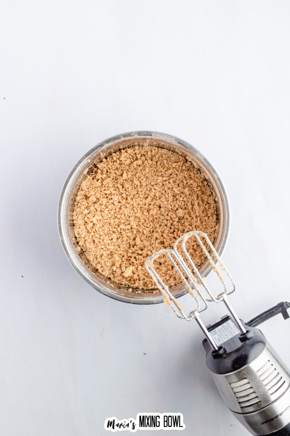 cinnamon crumb topping being mixed in a stainless steel bowl.