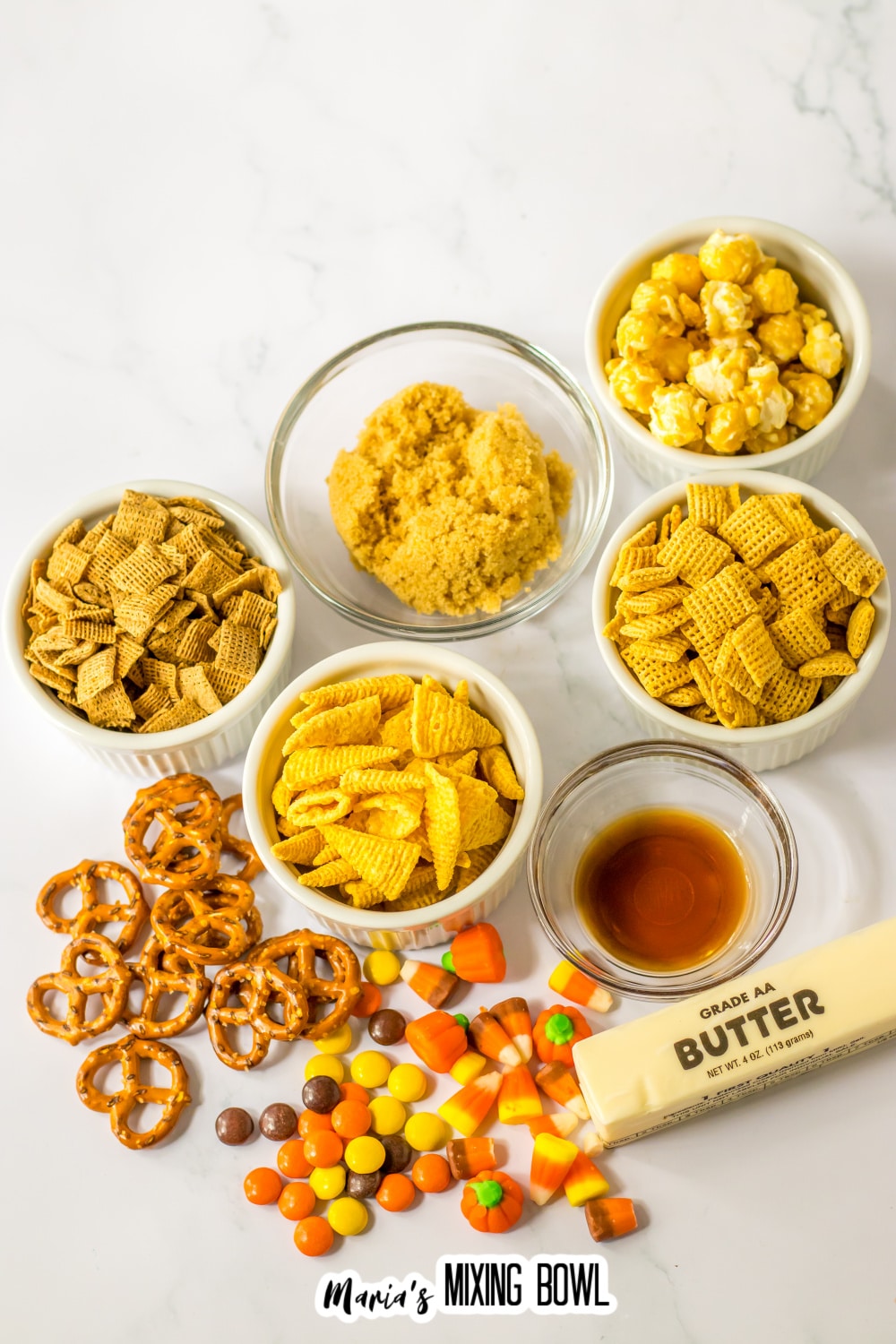 bowls of wheat chex, corn chex, pretzels, butter, caramel corn, brown sugar, vanilla extract, and candy corn.
