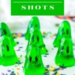 seven green gelatin ghosts on a white plate with sprinkles.