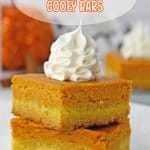 two gooey pumpkin bars stack on a plate.