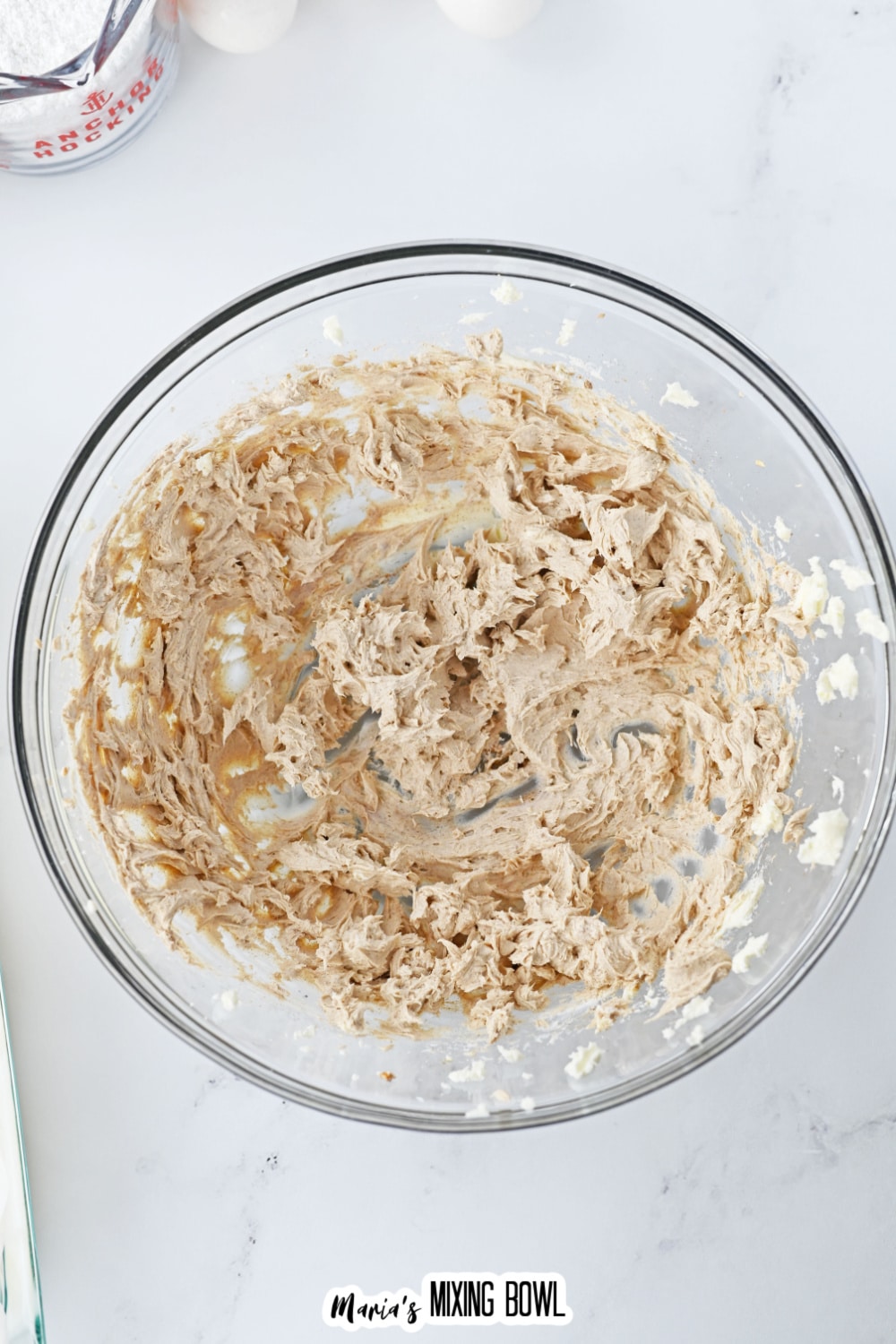 cream cheese and pumpkin being mixed in a glass bowl.