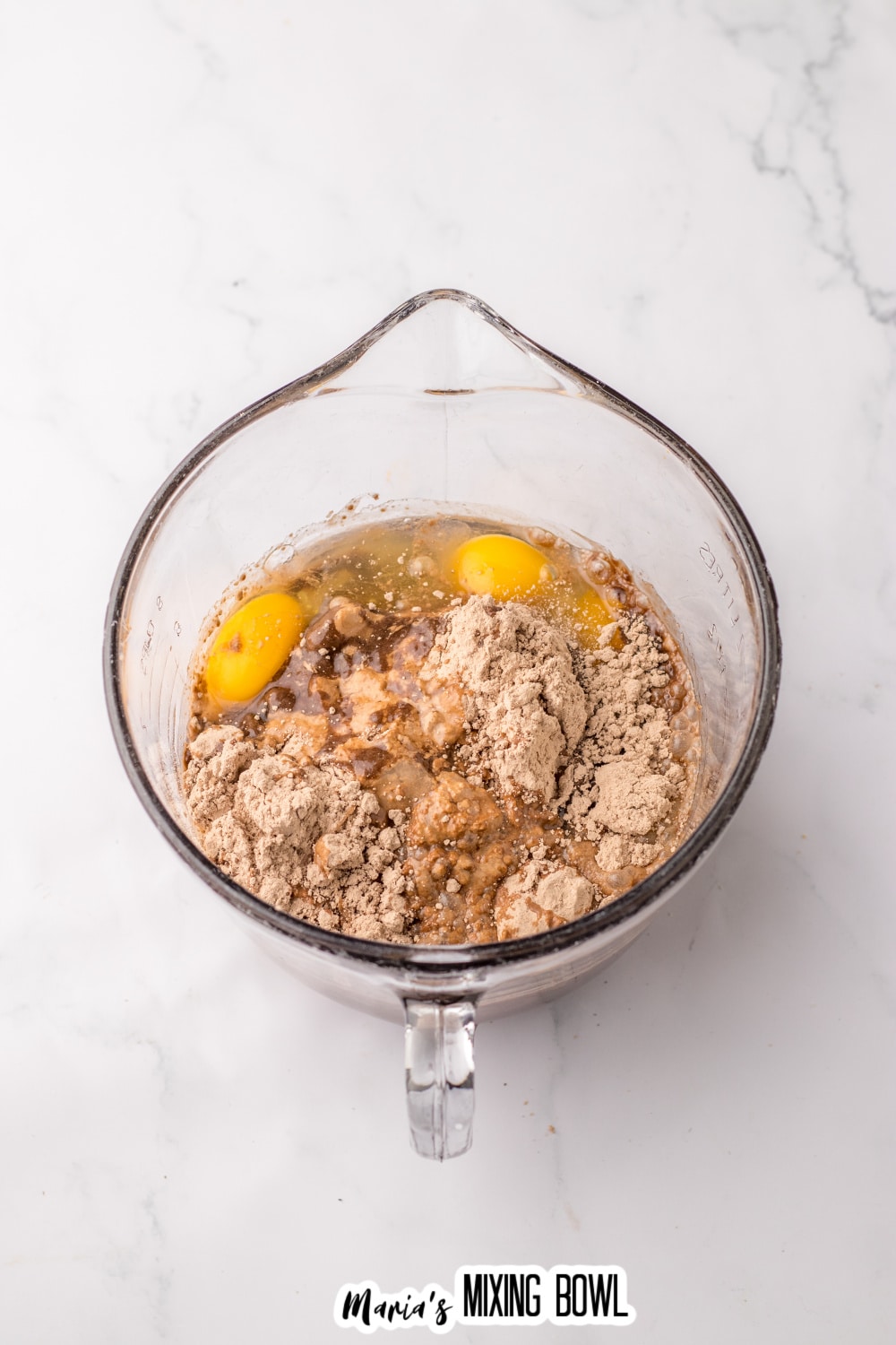 eggs, oil, and chocolate cake mix in a large glass mixing bowl.