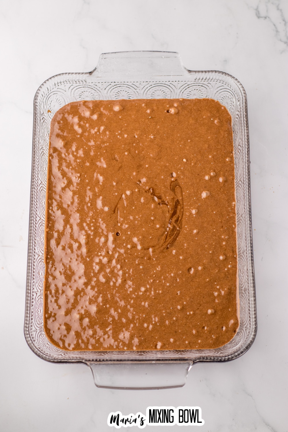 chocolate cake batter in a glass baking dish.