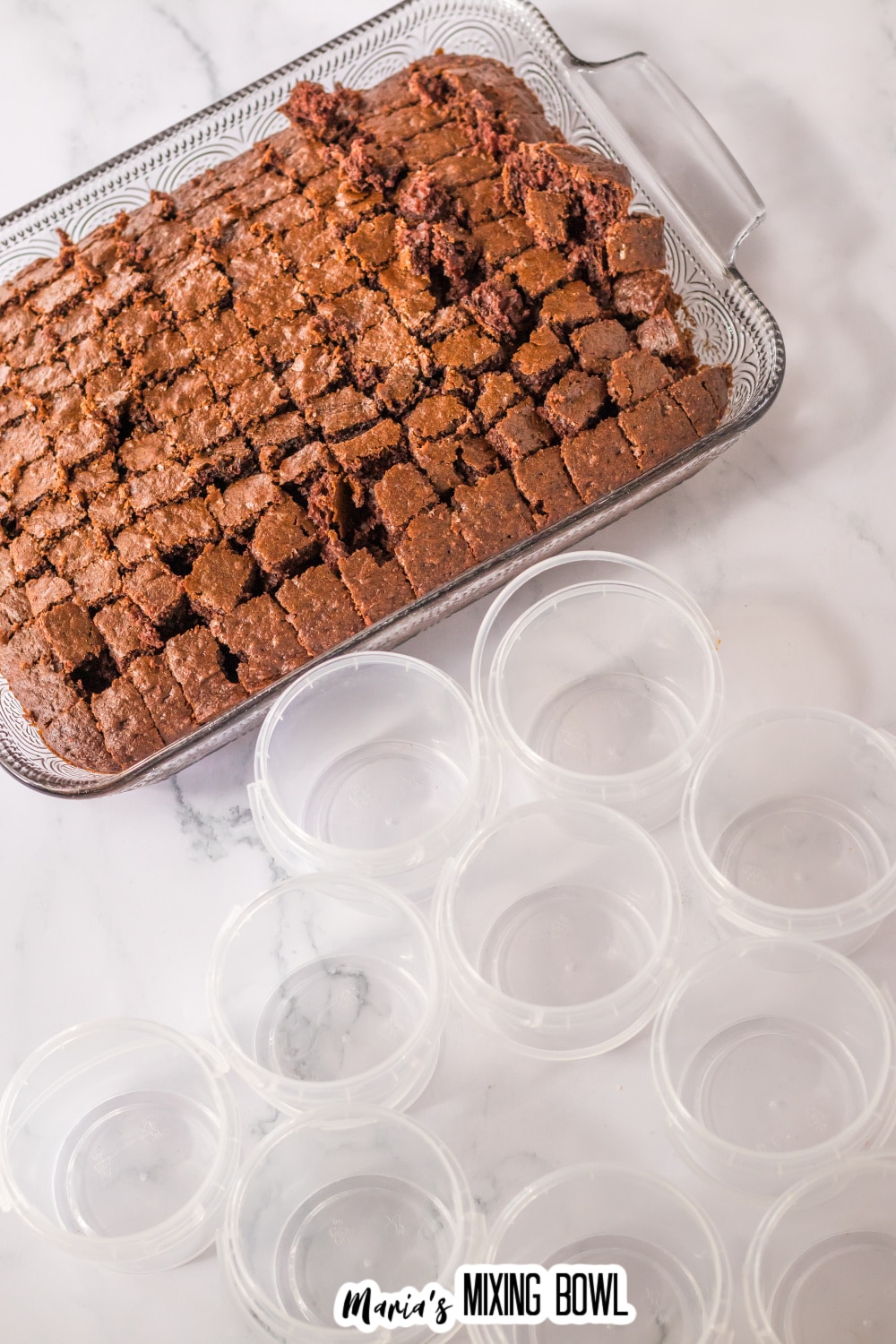 chocolate cake in a casserole dish being cut into bite sized pieces.