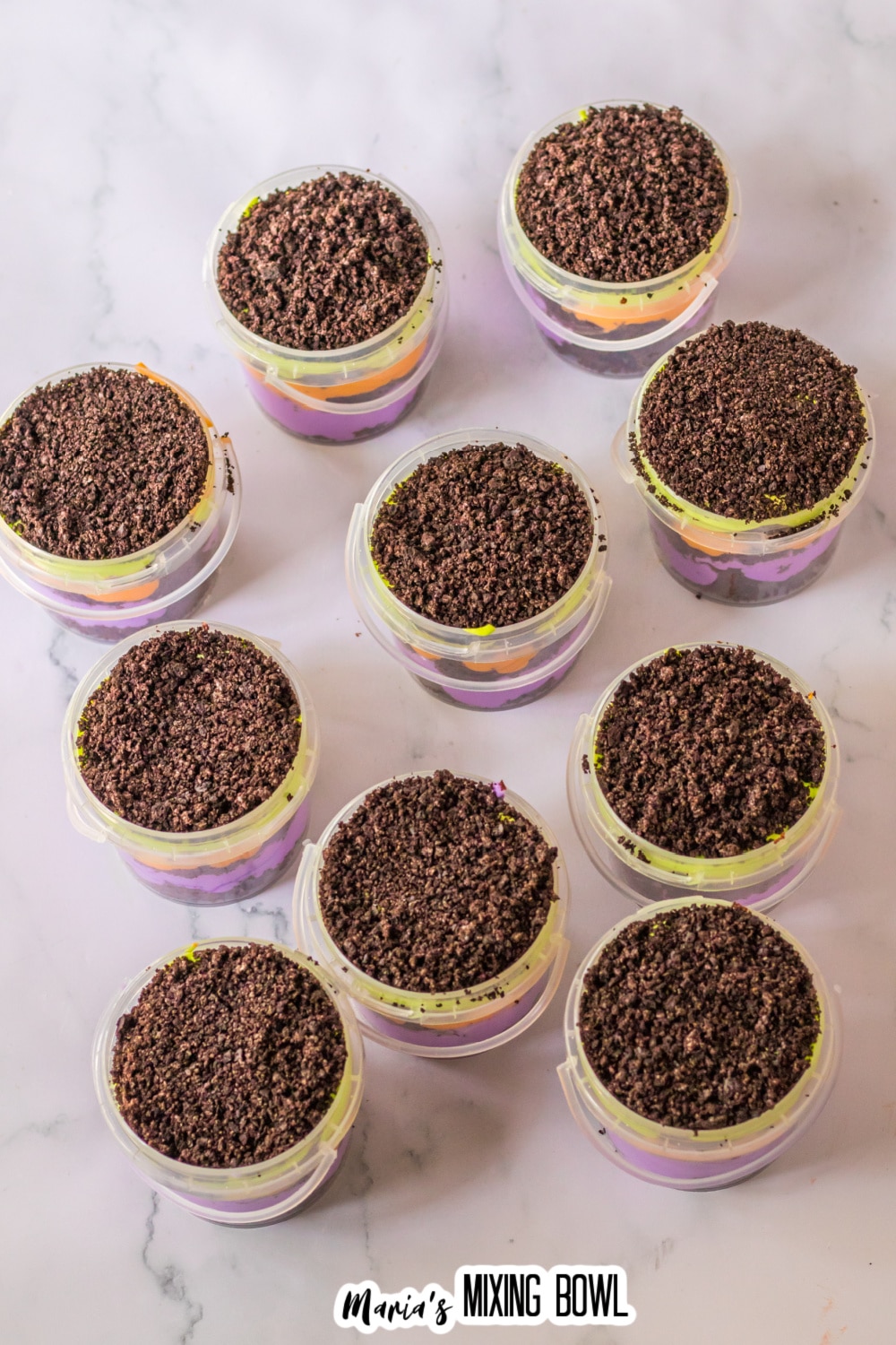 Oreo Cookie Crumbs being sprinkled on top of graveyard dirt cups.