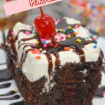 slice of hot fudge poke cake on a plate with a cherry on top.