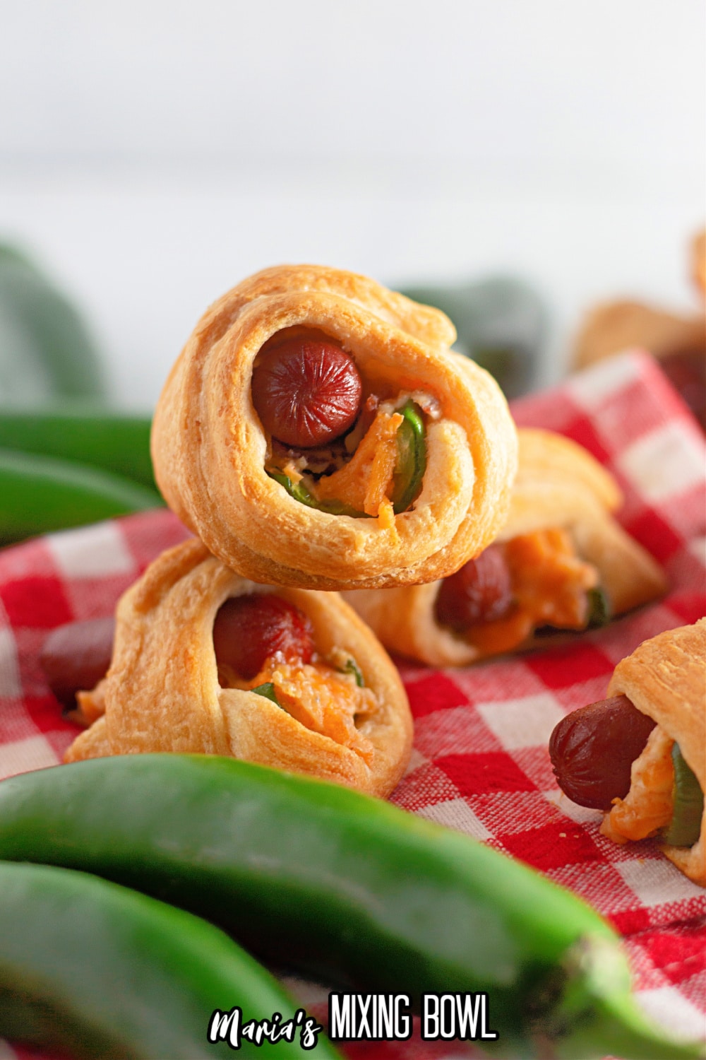 two jalapeno crescents pigs in a blanket stacked on top of each other.