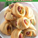 jalapeno crescents pigs in a blanket stacked on top of each other on a plate.