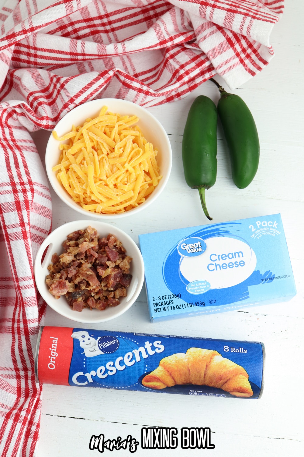 bowls of shredded cheese, cooked bacon, two jalapeno peppers, block of cream cheese, and can of crescent rolls.