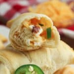 half of a jalapeno popper crescent roll cut open stacked on top of a whole one.
