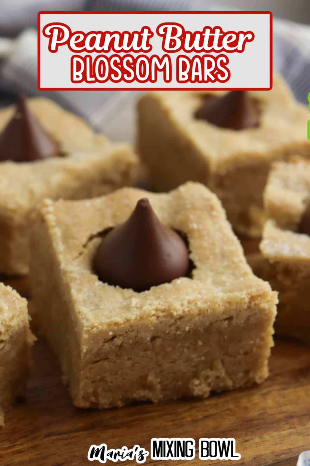six peanut butter blossom bars on a wooden cutting board.