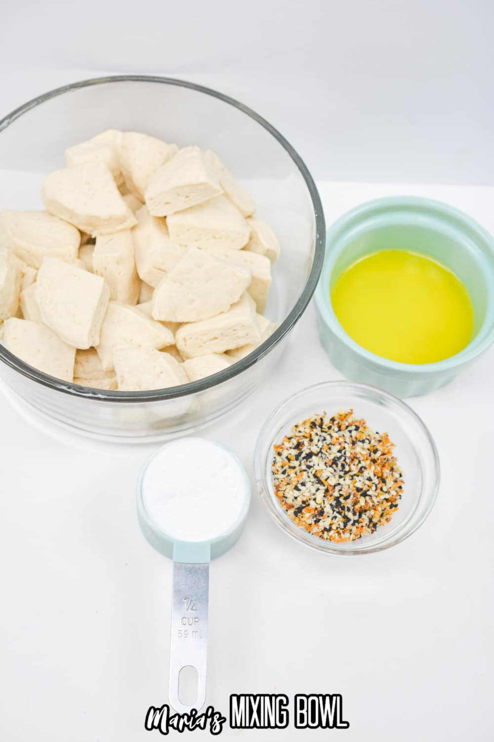 bowls of cut of biscuit pieces, melted butter, baking soda, and everything bagel seasoning.