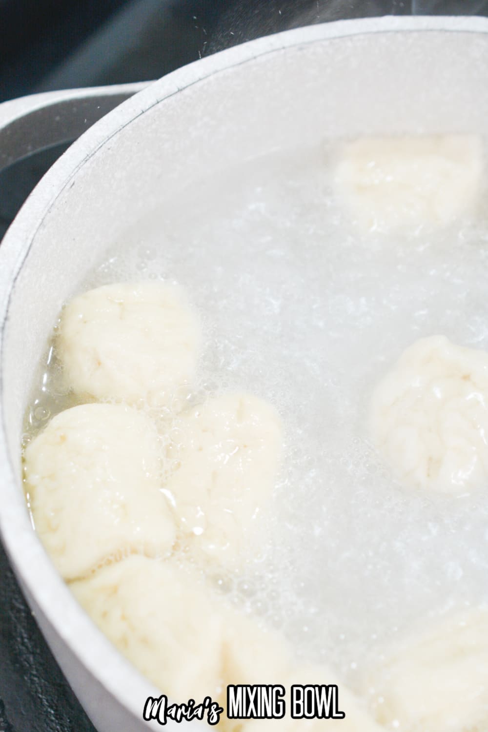 biscuit dough boiling in a saucepan filled with water and baking soda.
