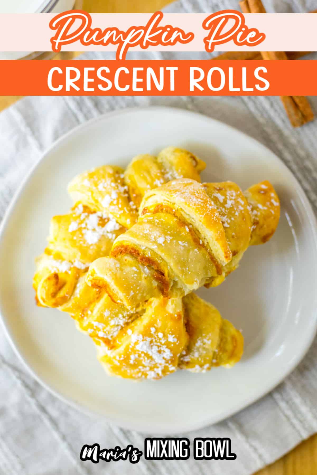 three pumpkin pie crescent rolls stacked on a white plate.