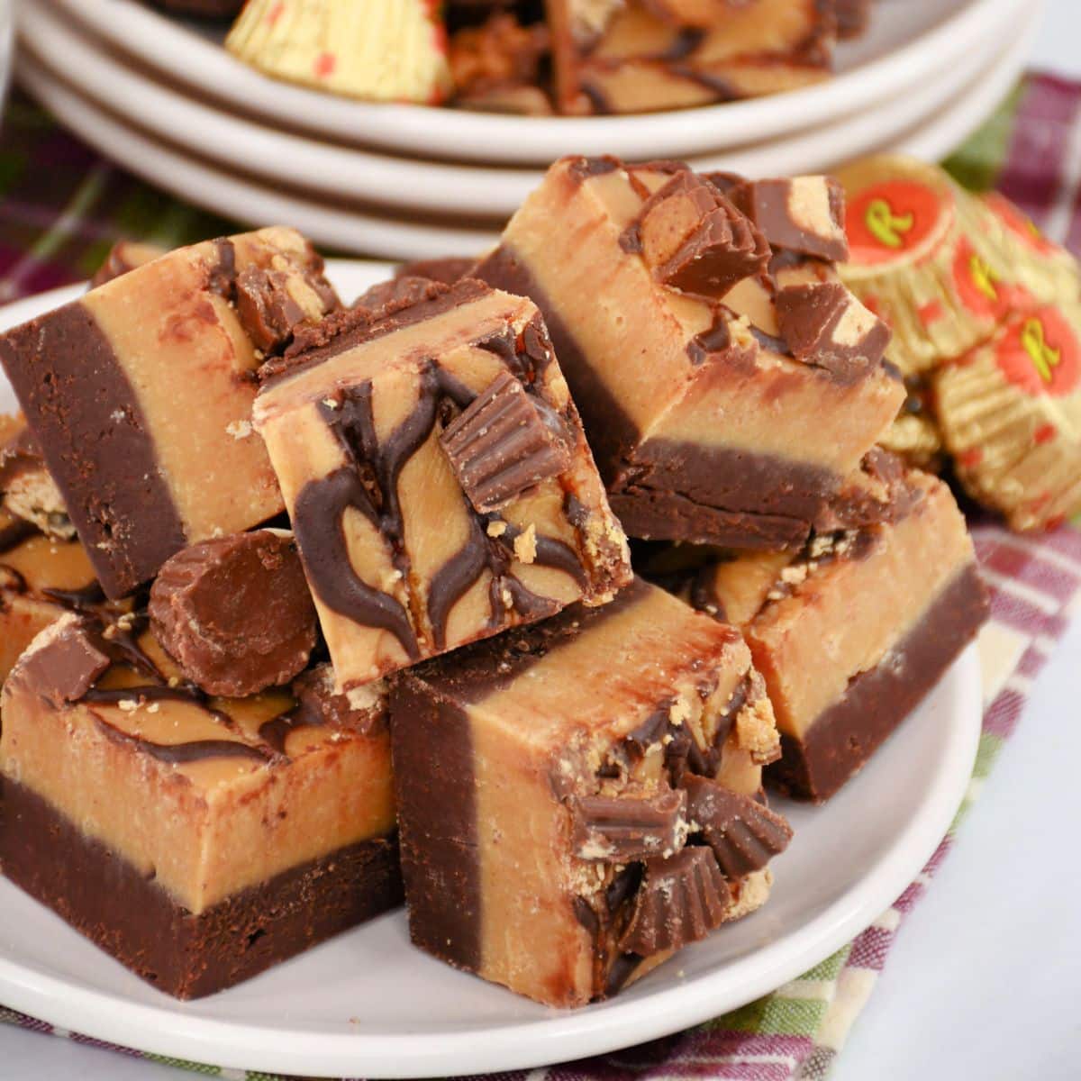 reese's peanut butter cup fudge staked on a white plate.