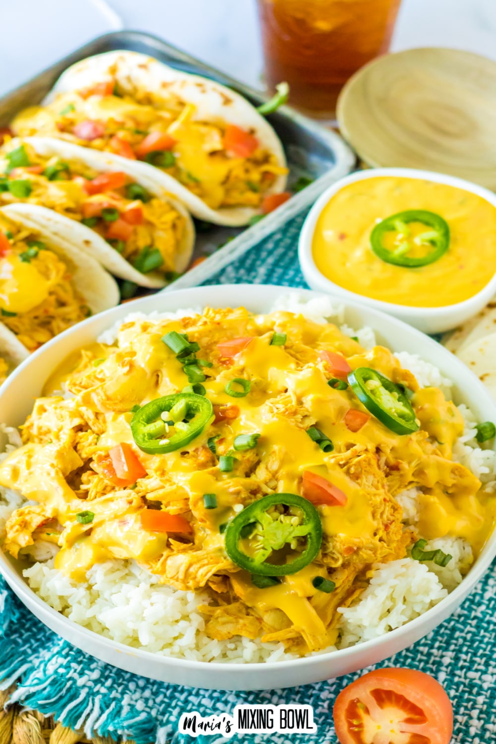 bowl of slow cooker queso chicken over rice and topped with jalapeno slices.