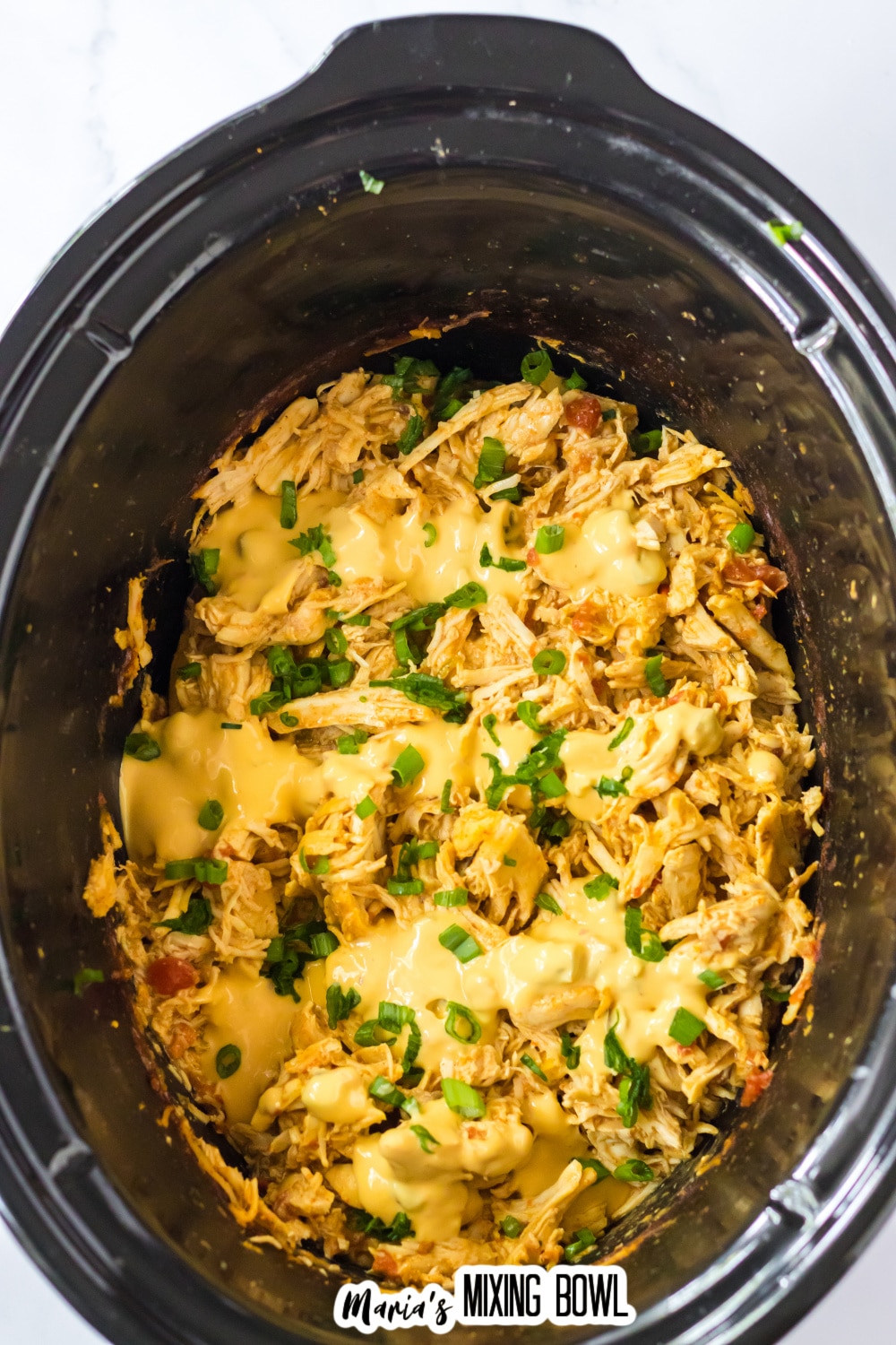 shredded queso chicken in a slow cooker.