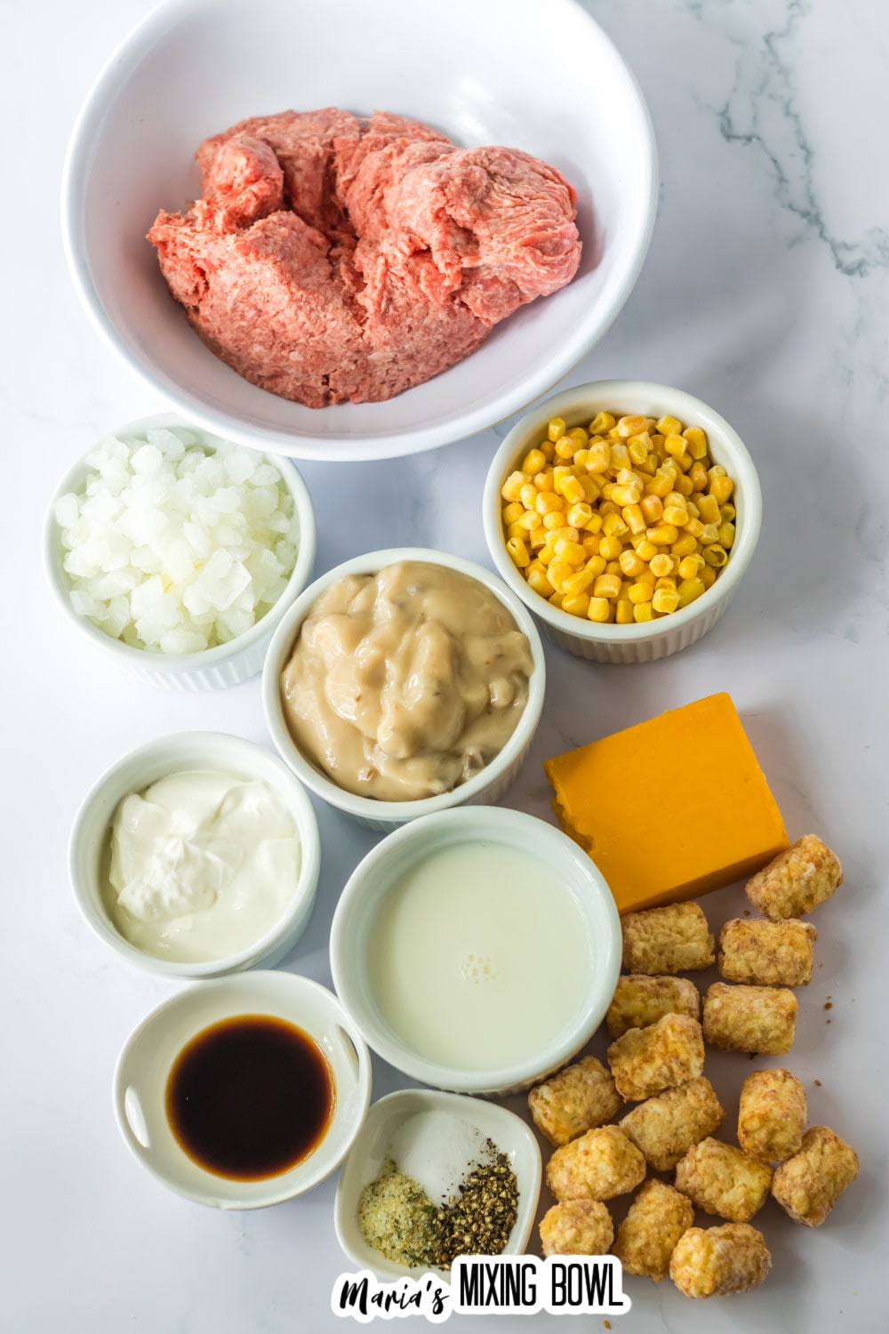 bowls of raw ground beef, onions, cream of mushroom, corn, sour cream, seasoning, tater tots, and cheese.