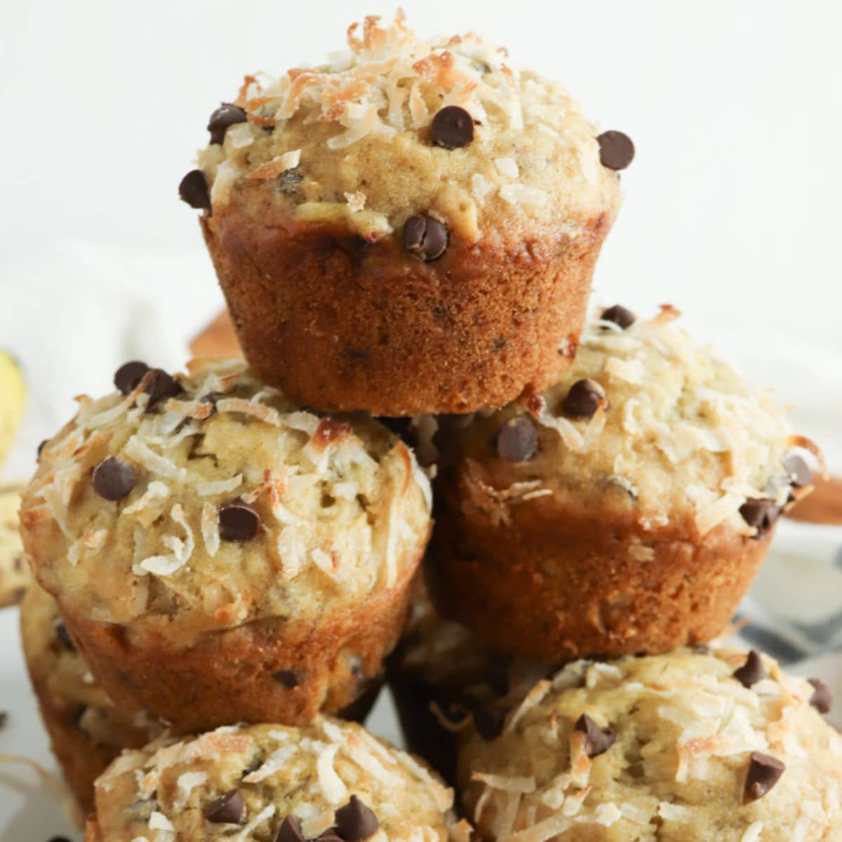 stack of banana coconut muffins on a plate.