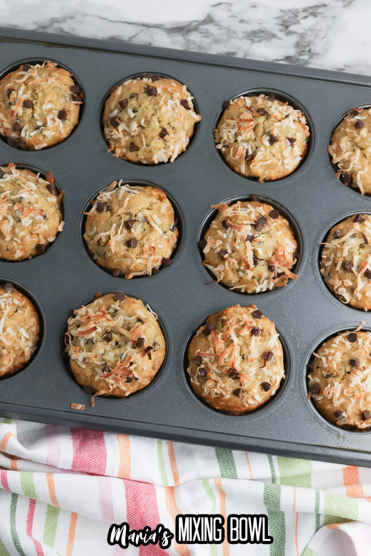 baked banana coconut muffins still in a metal baking pan.