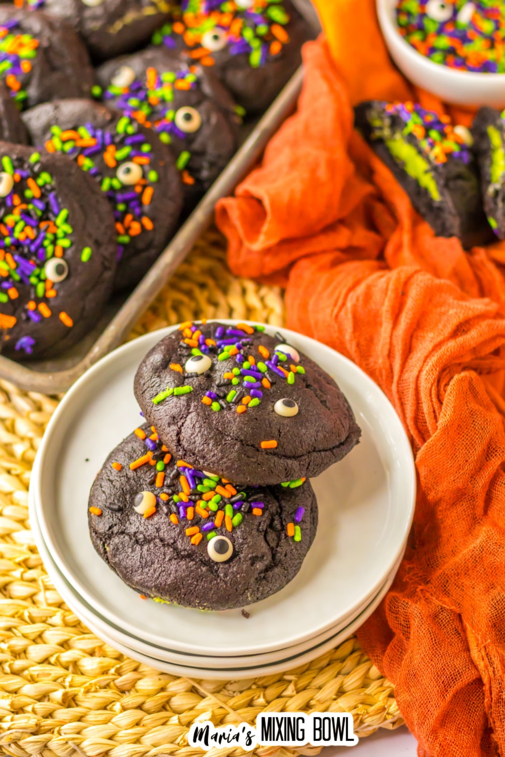 two black velvet cookies on a small stack of plates.