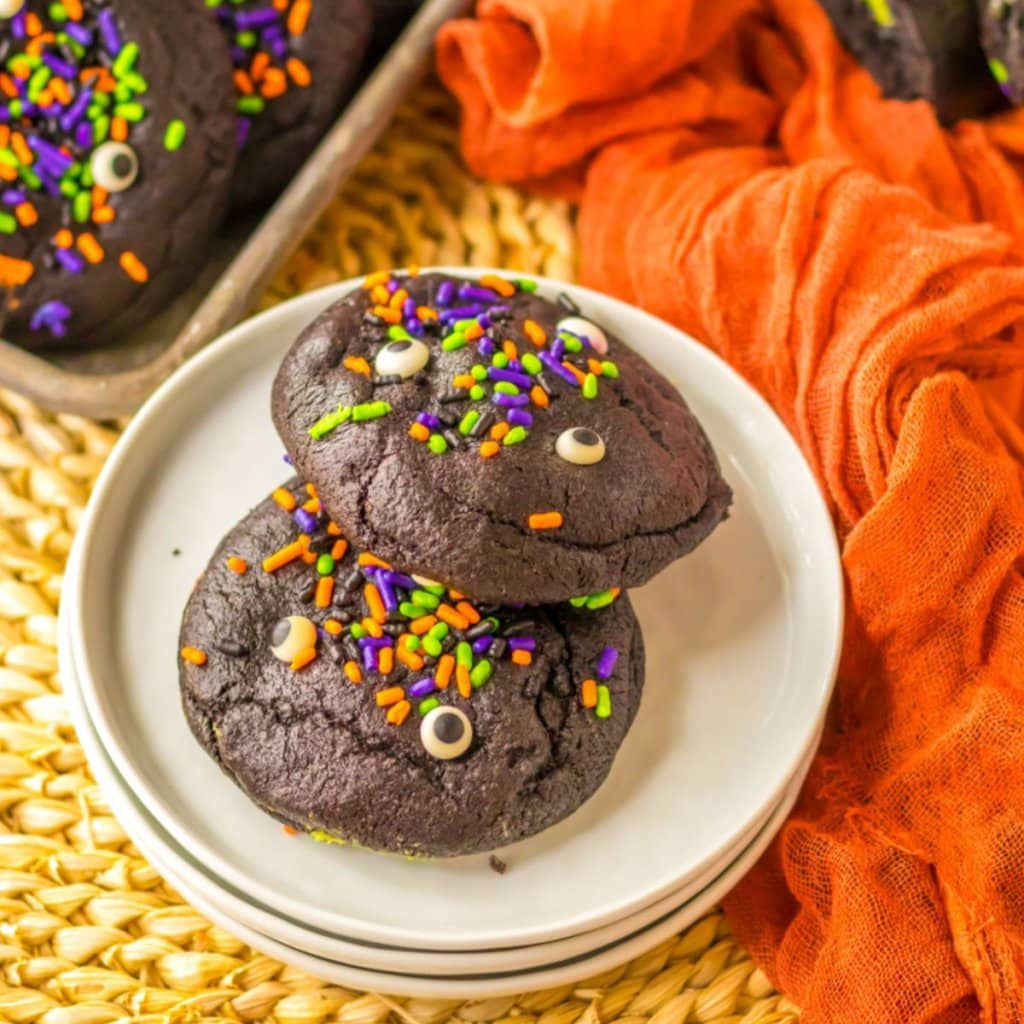 two black velvet cookies on a small stack of plates.