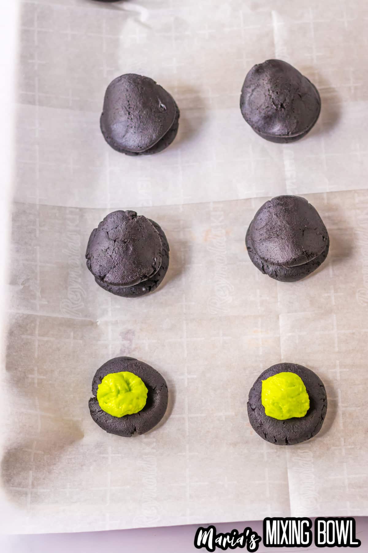 frozen cheesecake being stuffed inside black velvet cookies.