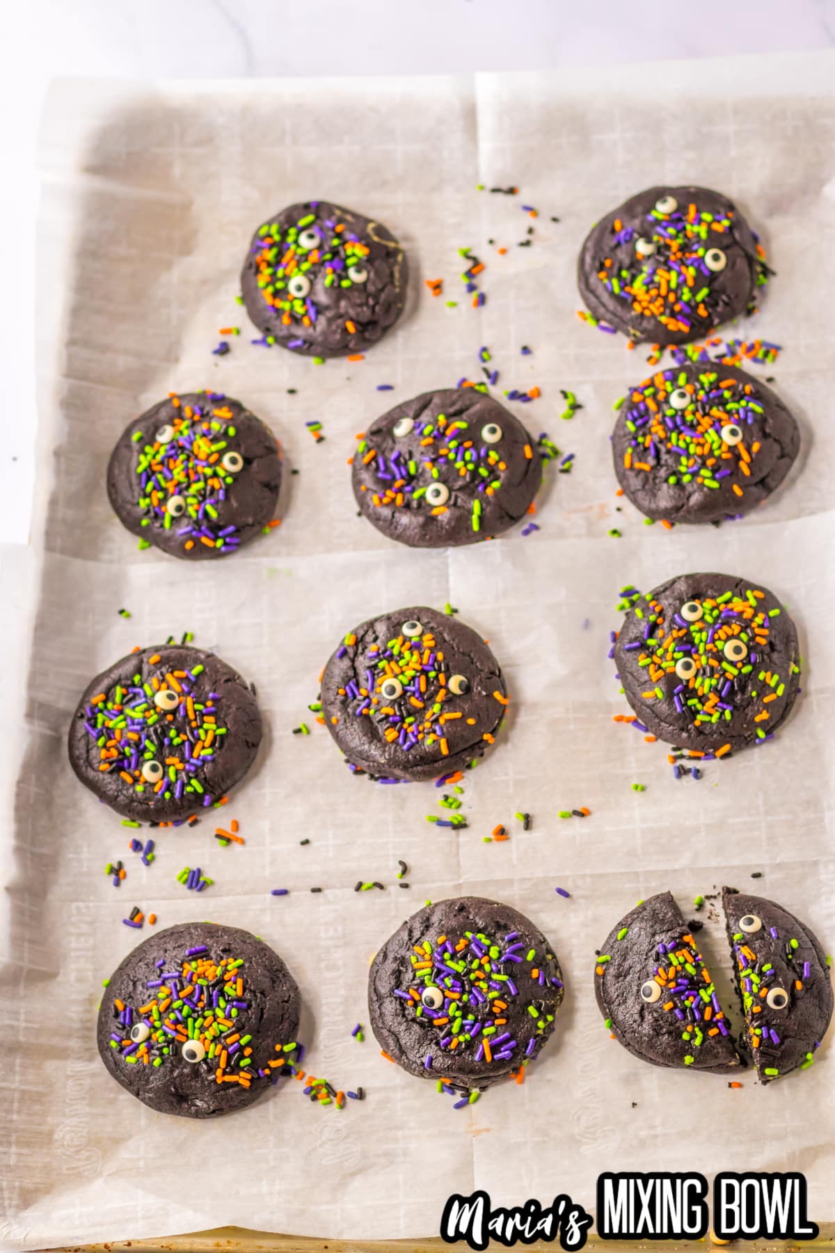 baked black velvet cookies cooling on a parchment lined baking sheet.