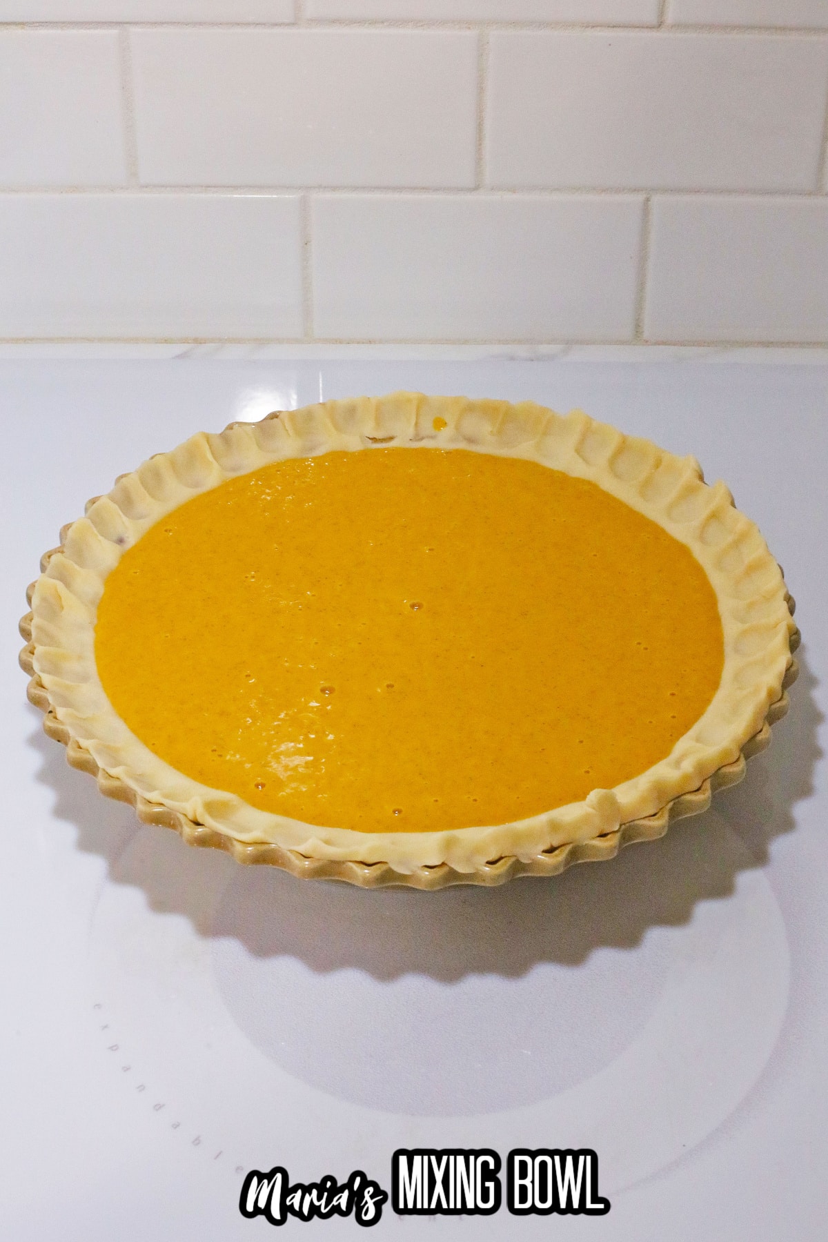 pie filling being poured into a pie crust in a pie plate.