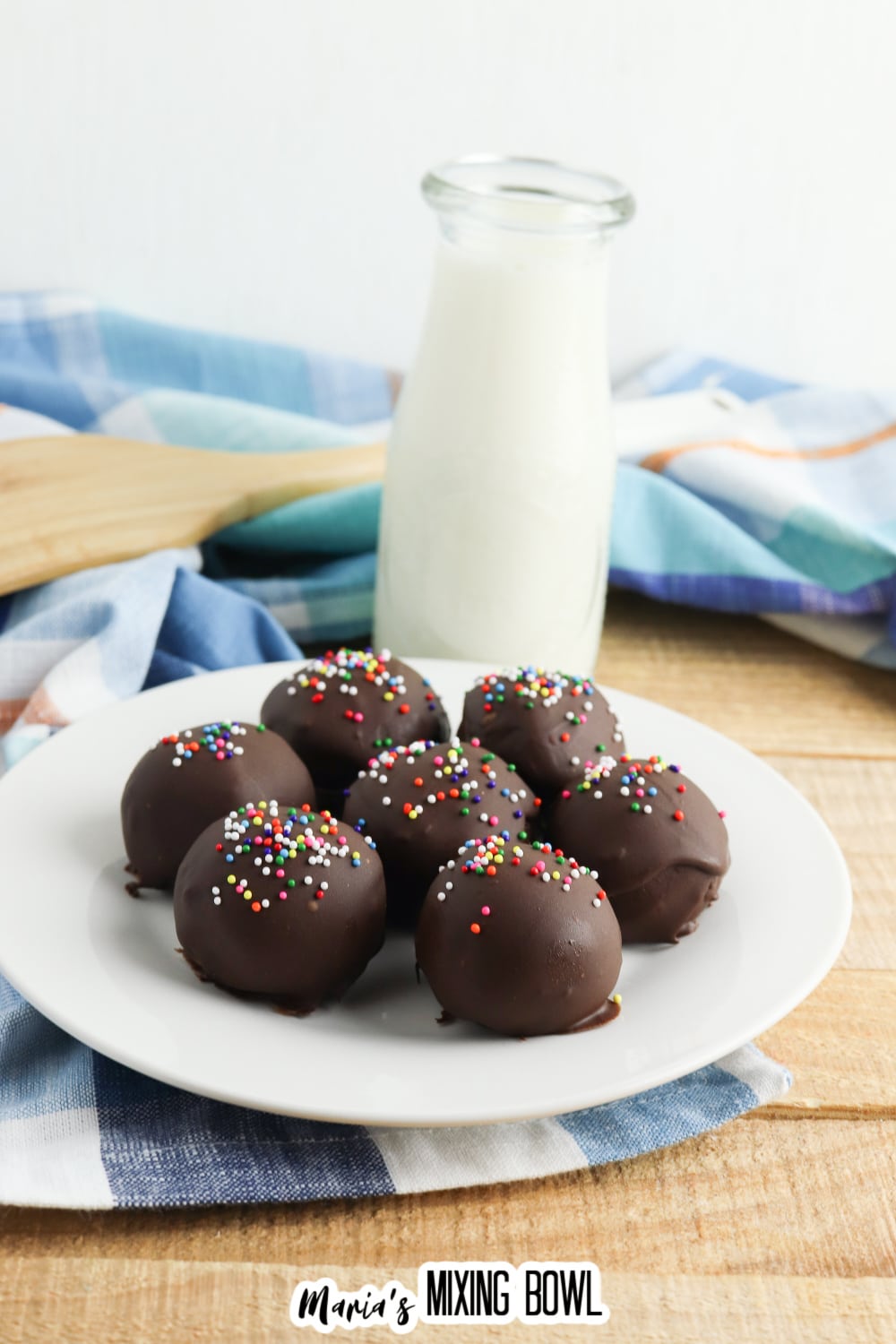 seven brownie truffles on a white plate.