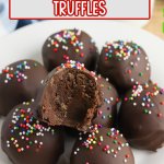 stack of brownie truffles on a white plate, the top one has a bite missing.