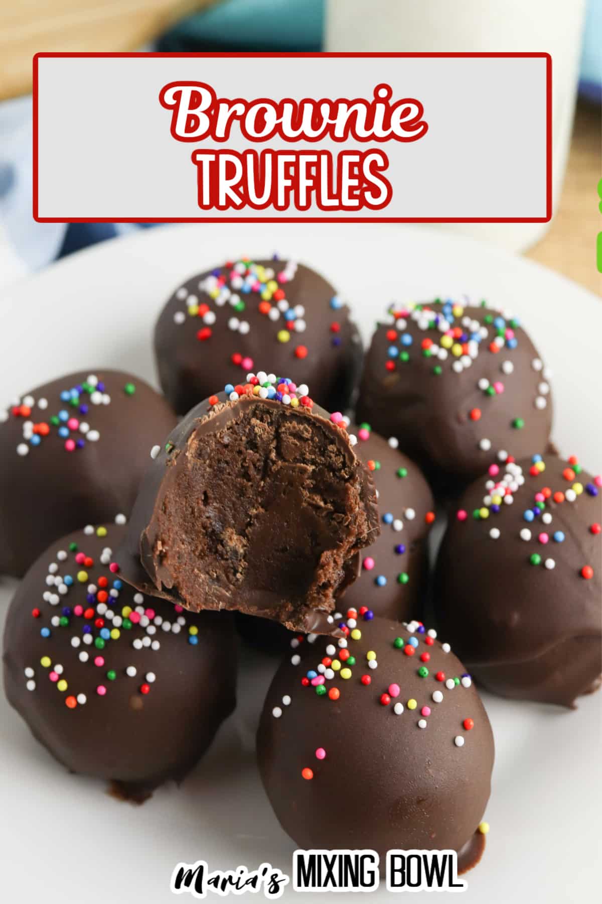stack of brownie truffles on a white plate, the top one has a bite missing.