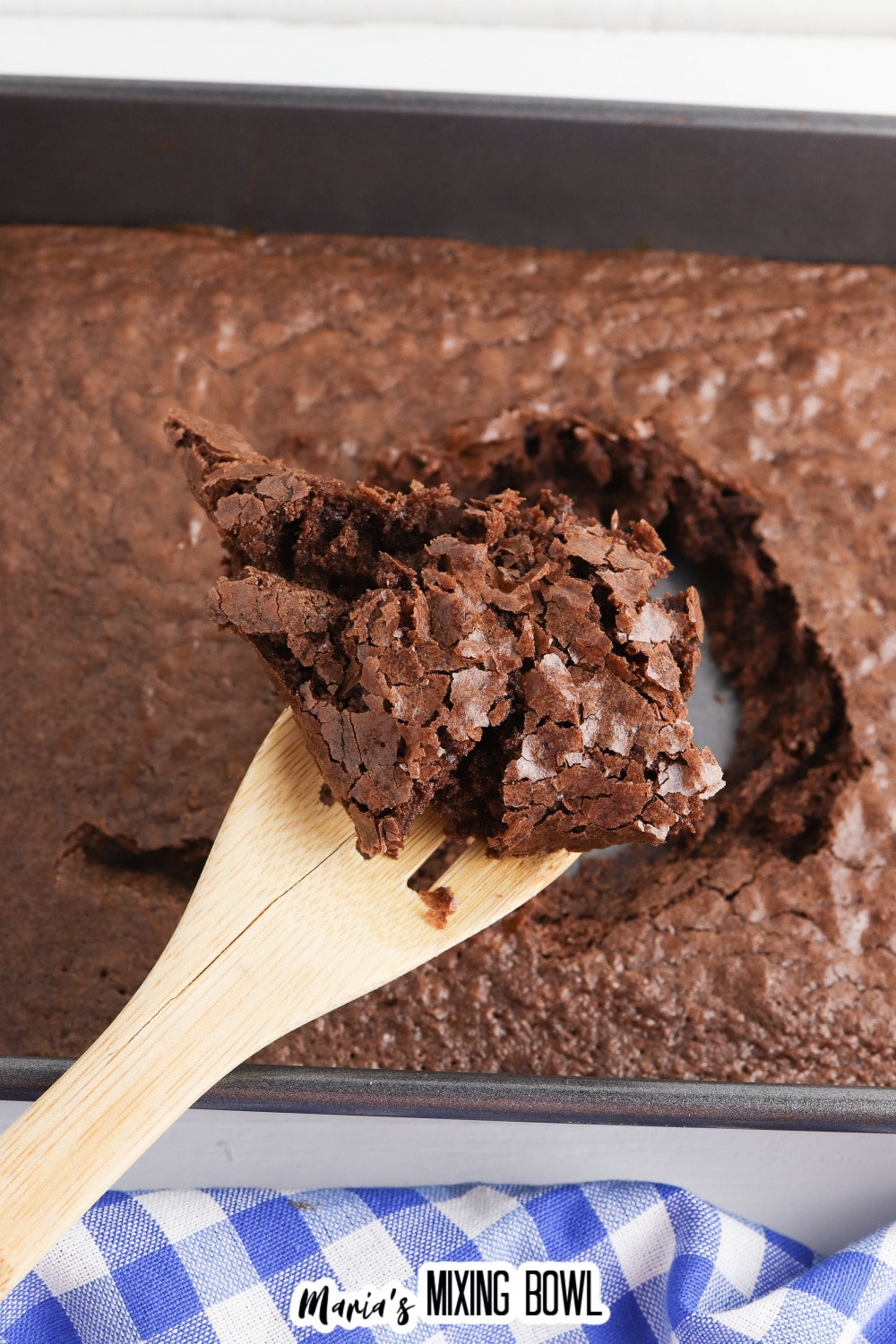 baked brownies being scooped out of a baking dish.