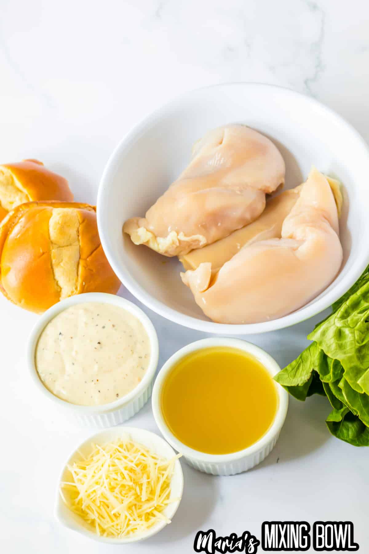 bowls of raw chicken breast, ceasar dressing, chicken broth, and parmesan cheese.