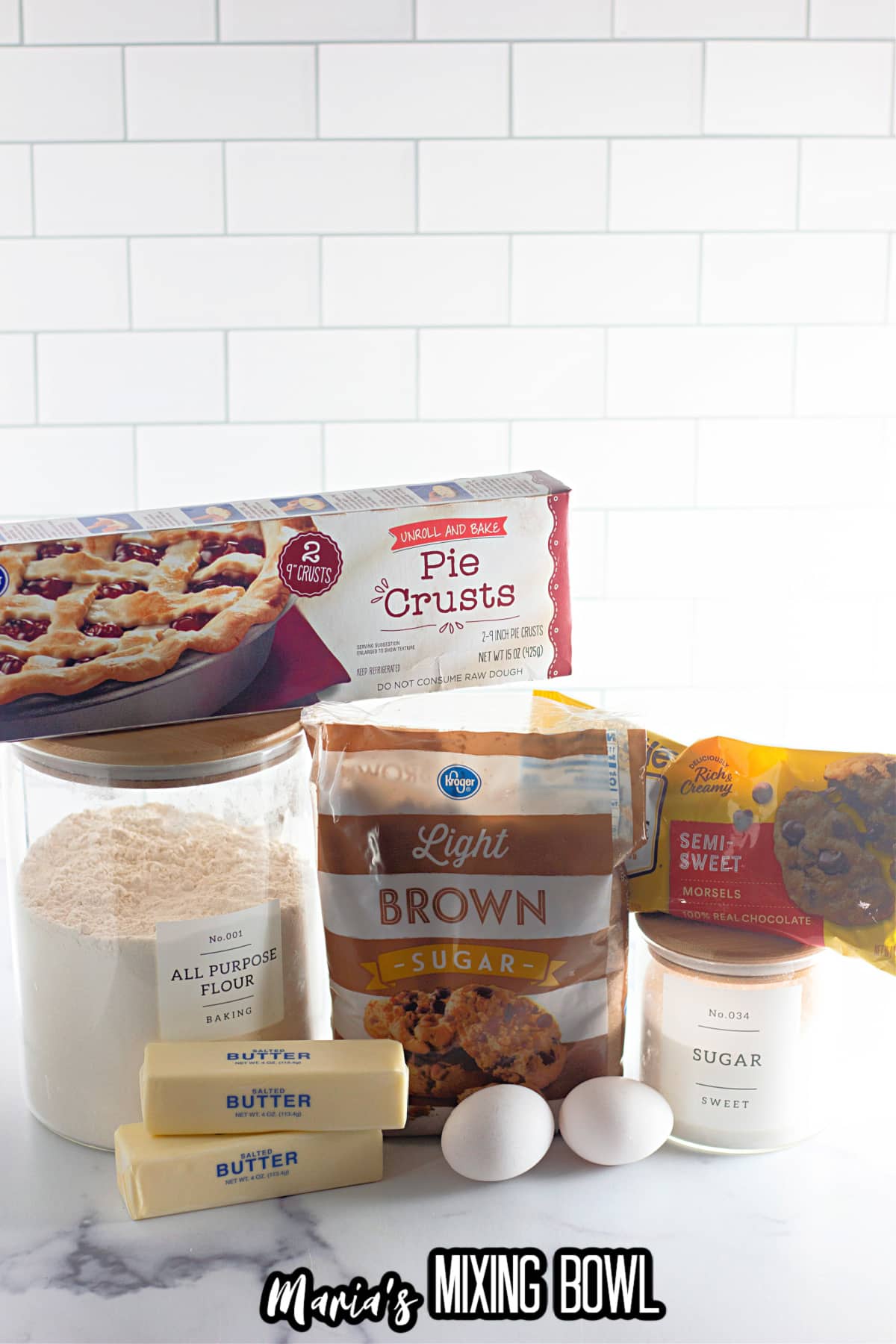 pie crusts, all purpose flour, butter, eggs, brown sugar, chocolate chips and granulated sugar on a counter.