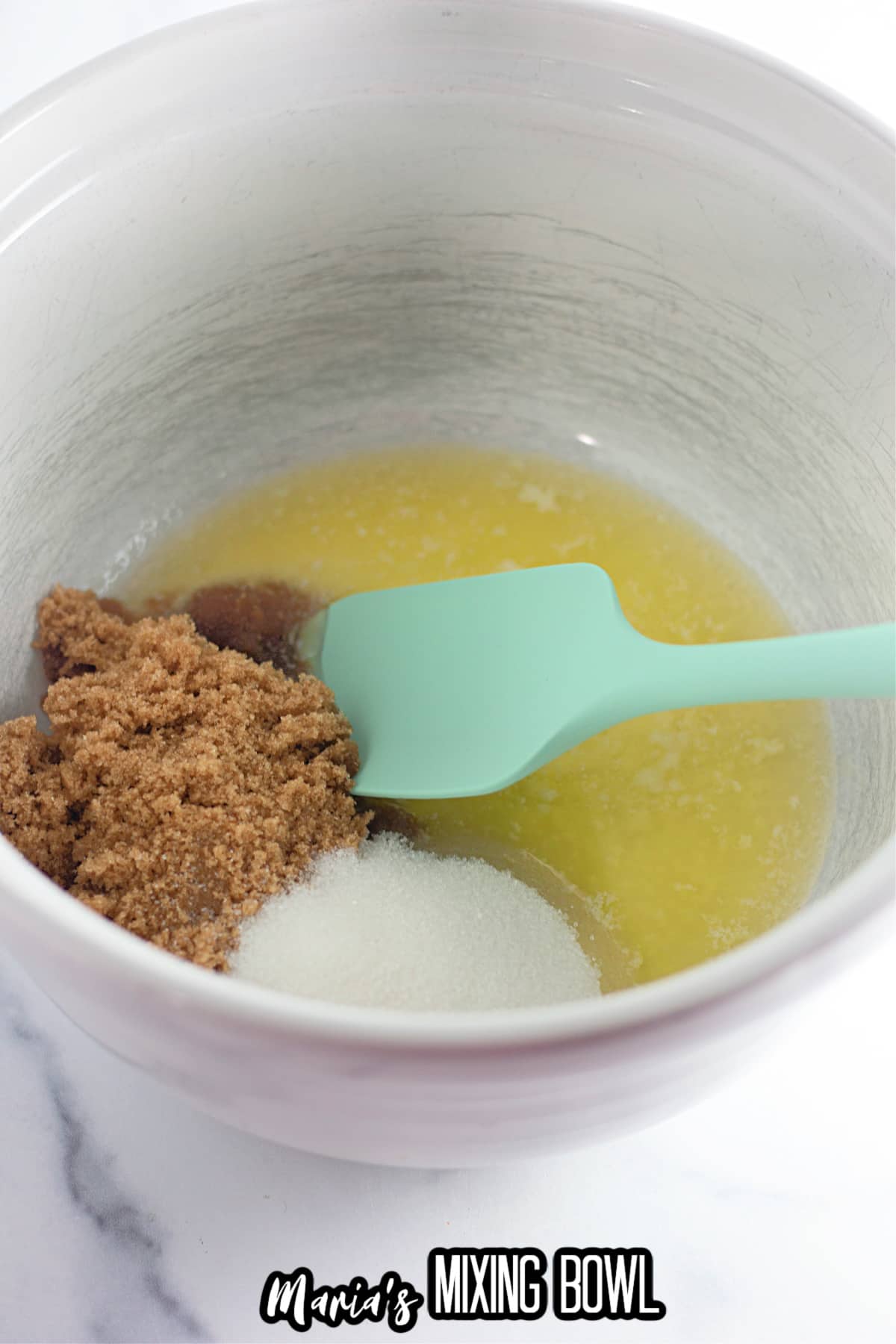 mixing bowl filled with melted butter, brown sugar, and granulated sugar.