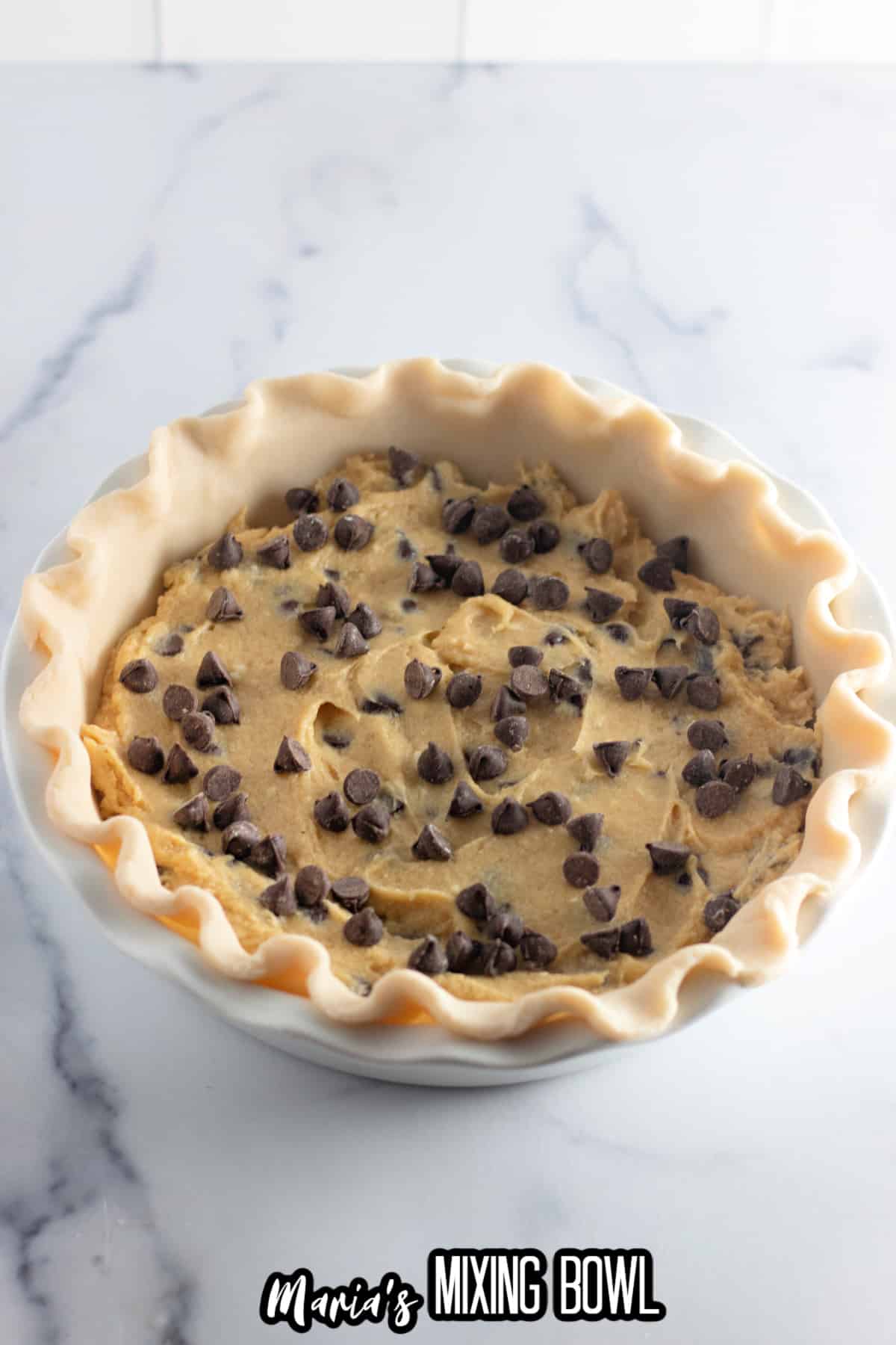 pie crust filled with chocolate chip cookie dough ready to go into the oven.