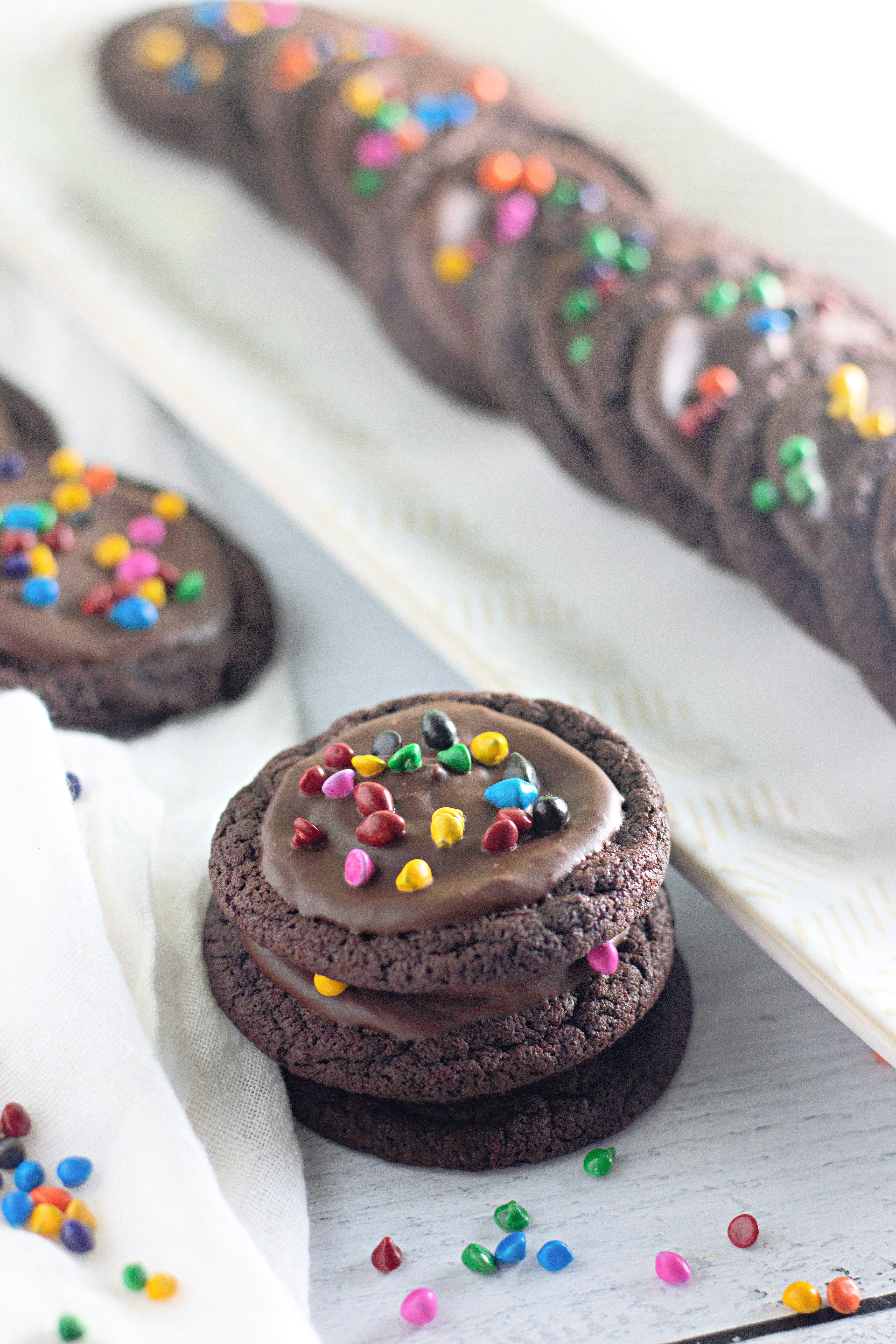 three cosmic brownie cookies stacked on a table.